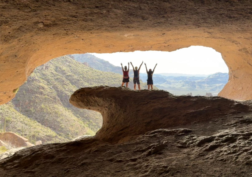 Hikers in Wave Cave raising arms—breakthrough.