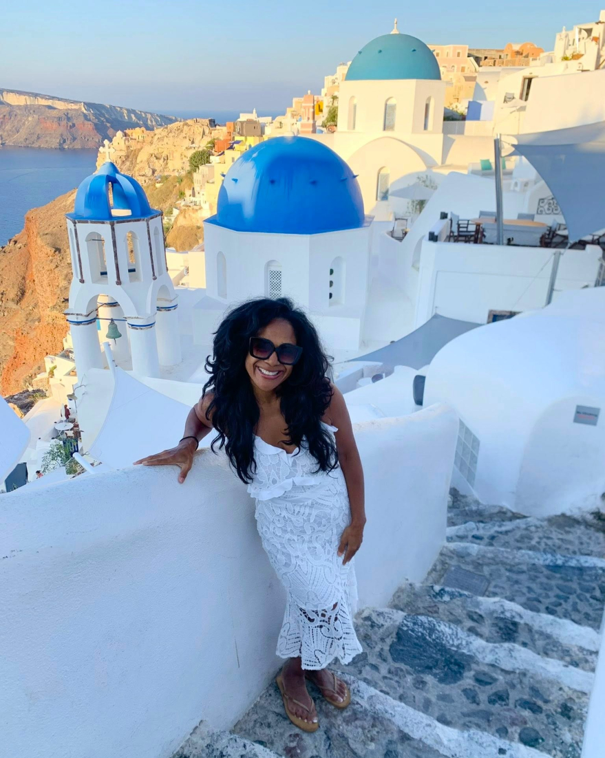 Kim Peterson in Santorini, Greece—embodying curiosity, authenticity, and resilience.