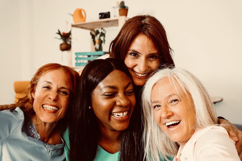 Diverse women smiling together, symbolizing confidence, connection, and resilience.