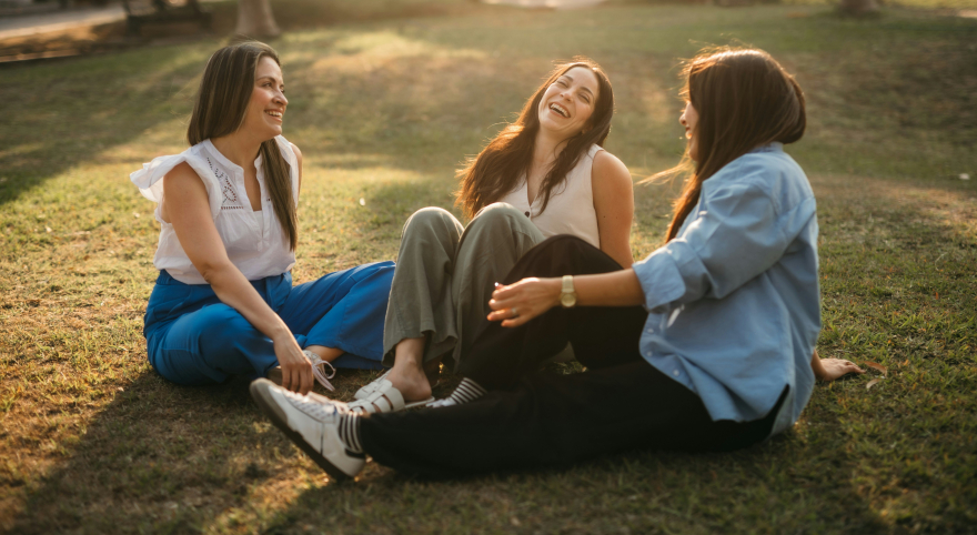 Women laughing at sunset—belonging and joy.