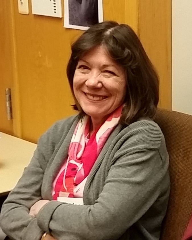 Kathleen Paris, sitting in a chair and smiling