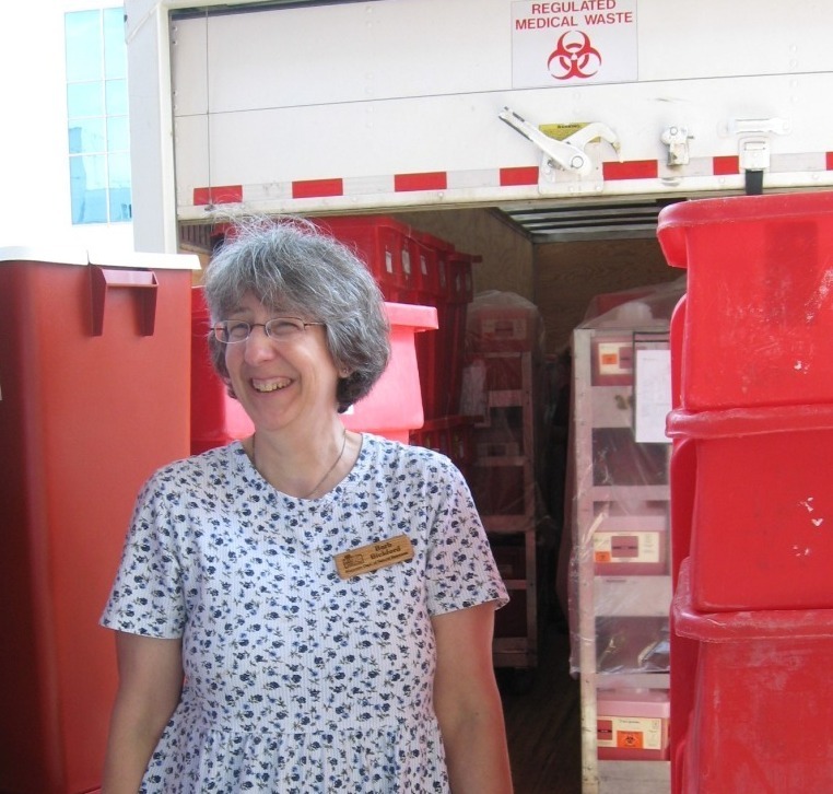 woman standing in front of a medical waste truck