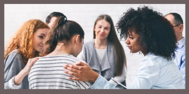 Women in a group, consoling each other