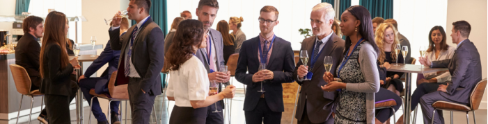 People talking in small groups at a conference People talking in small groups at a conference