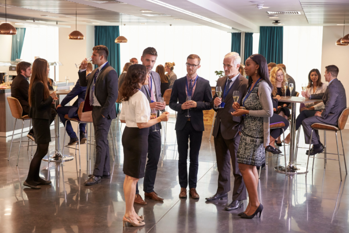 Professionals mingling in an in-person networking session Professionals mingling in an in-person networking session