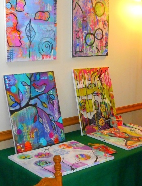 four paintings on the wall at a Transitions Retreat